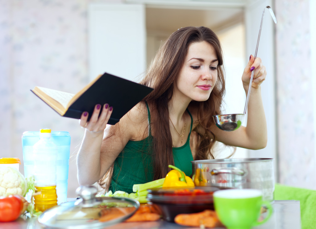 woman smelling the food she's preparing in the kitchen