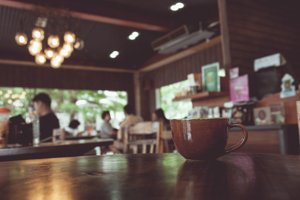 vintage tone of cup of coffee on table in Coffee shop blur background with bokeh image.