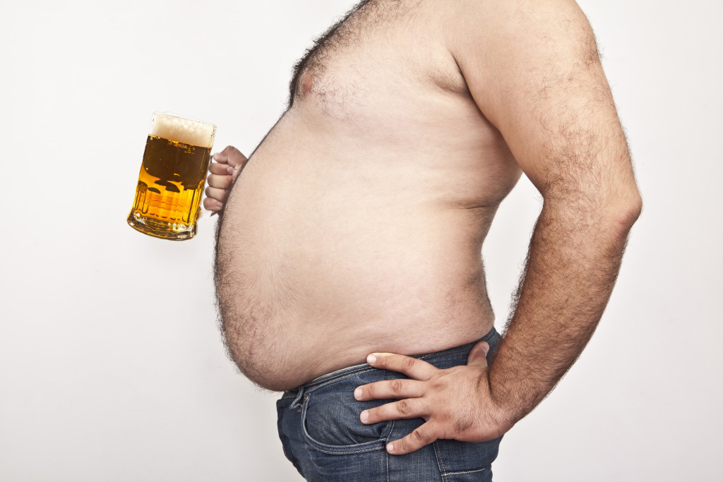 obese man drinking beer
