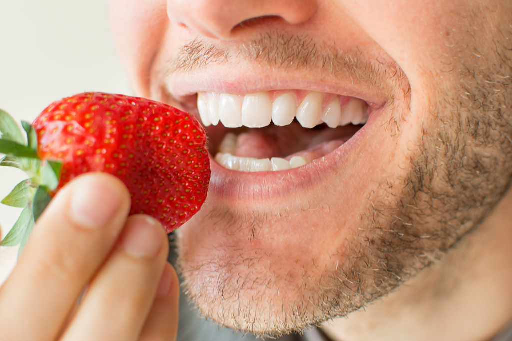 a man eating a strawberry