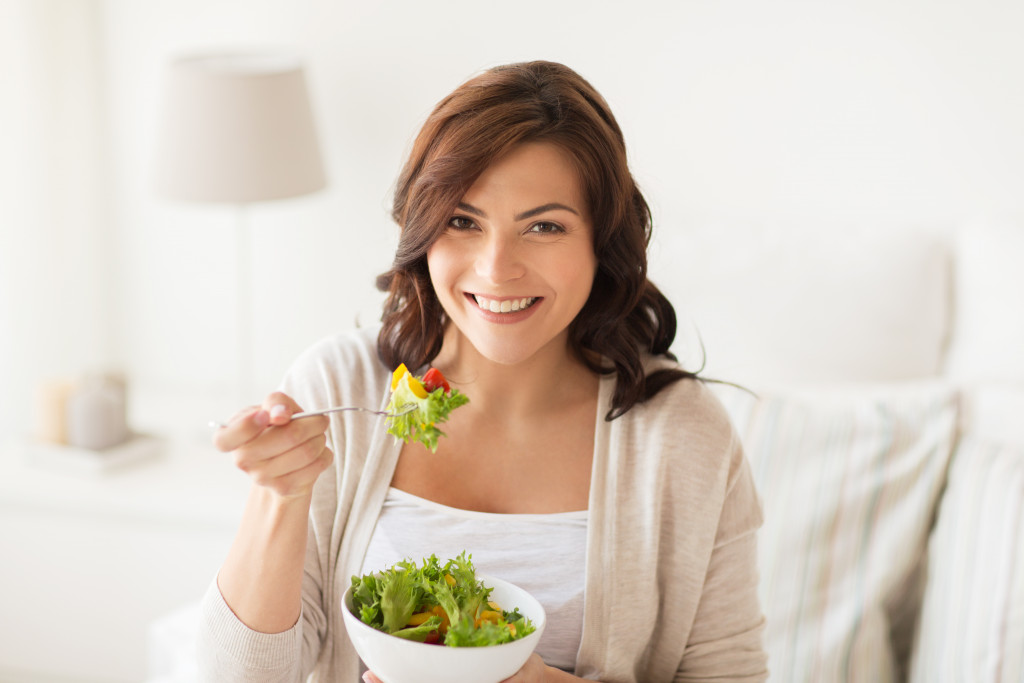 woman eating a bowl of vegetable sald