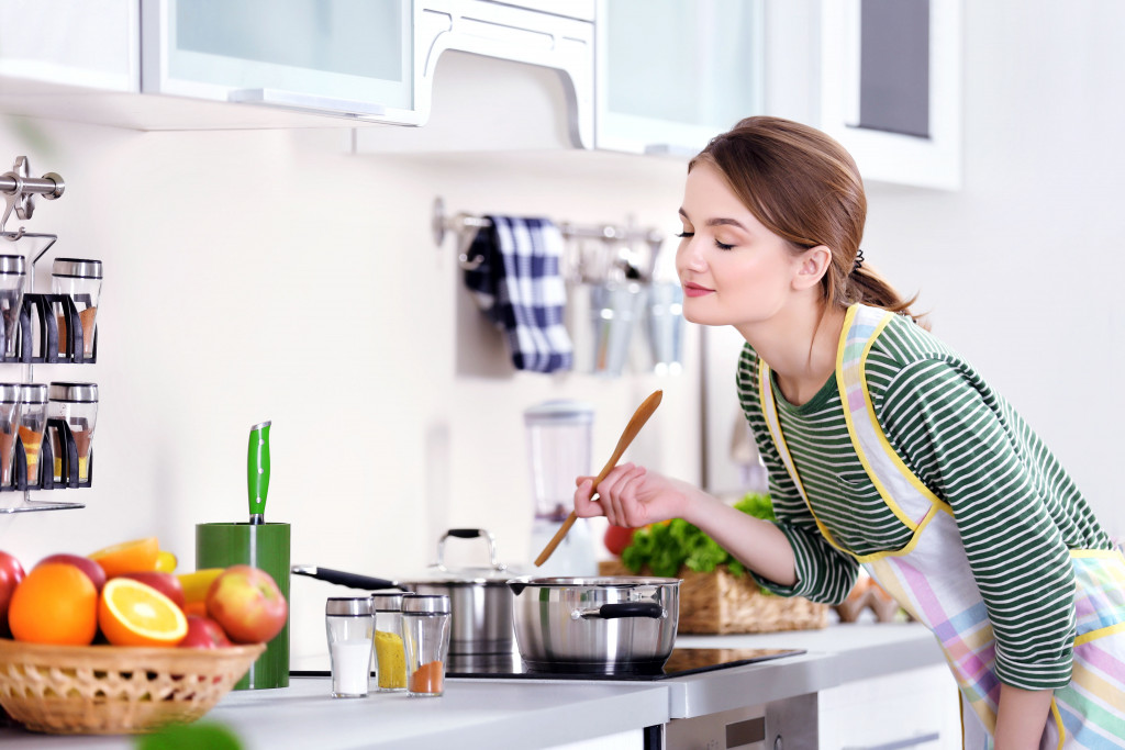 Woman tastes food she's cooking