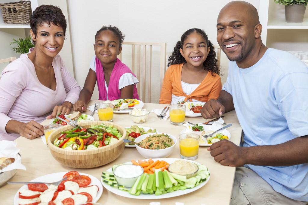 Small family eating a healthy meal consisting of fruits and vegetables at home