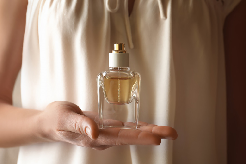 A lady holding a perfume bottle