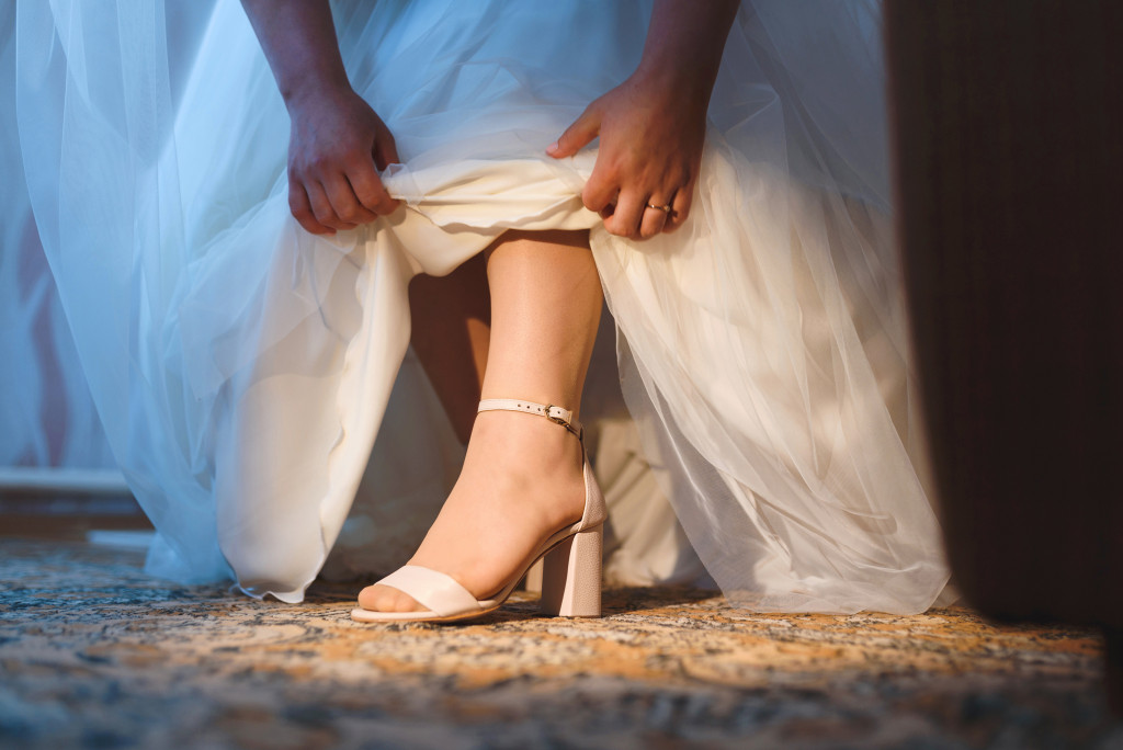 a bride showing her wedding shoes