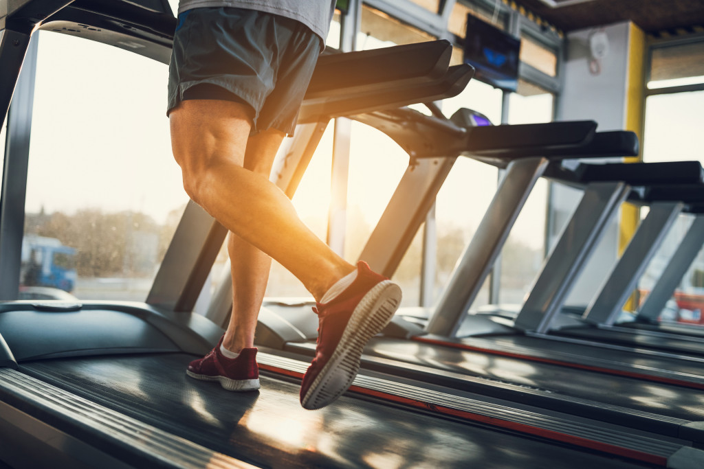 man running in a treadmill in a gym at sunrise