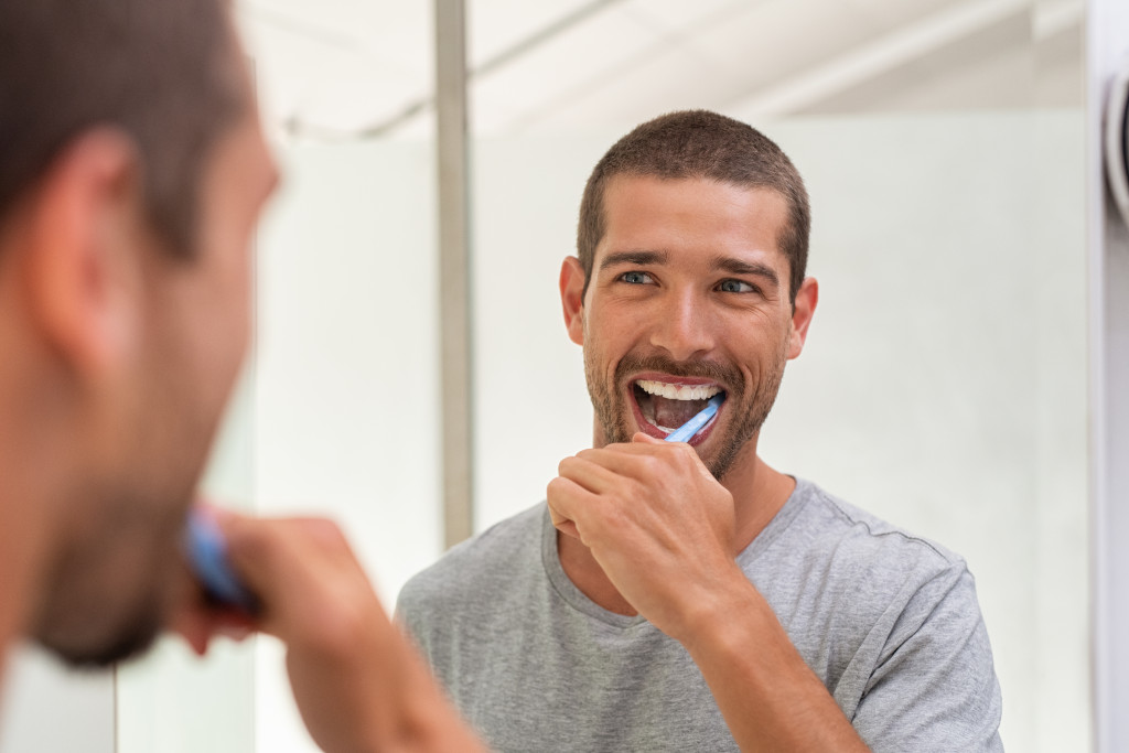 a man brushing teeth in front of a mirror