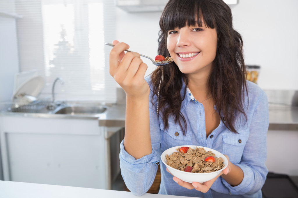 A woman eating oats and fruit for breakfast