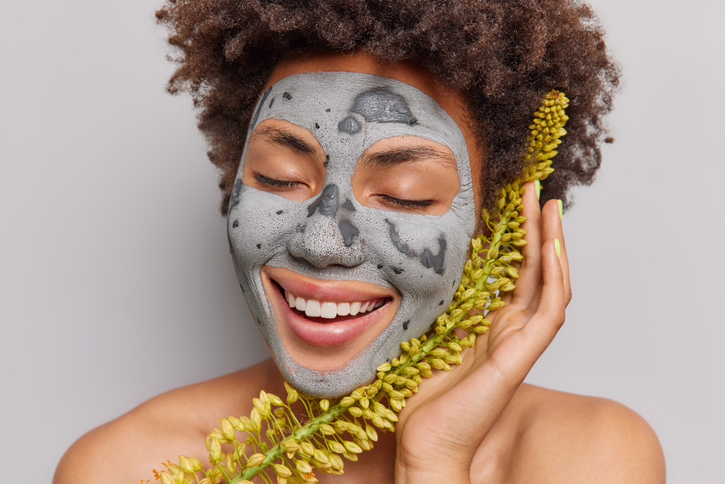 woman exfoliating with clay mask